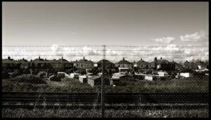 Chain link fence and houses by railway