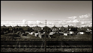 Chain link fence and houses by railway Chain link fence and houses by railway
