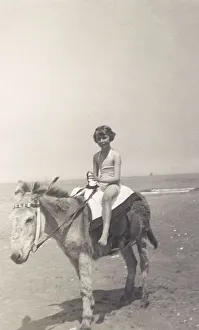<b class=qtipBold><figcaption>Child riding a seaside donkey</figcaption></b><br>Child riding a seaside donkey (called 'Charlie'), who looks totally bored with his lot... Date: circa 1930s<br><em>© Grenville Collins Postcard Collection / Tom Gillmor / Mary Evans</em> Child riding a seaside donkey