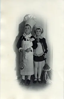 Two children in fancy dress; the little boy is dressed as a chef while a little girl Two children in fancy dress; the little boy is dressed as a chef while a little girl