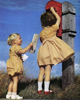 <b class=qtipBold><figcaption>Children posting a letter</figcaption></b><br>Two children, dressed in adorable matching yellow outfits, post a letter at a rather remote looking postbox. Date: 1951<br><em>© Illustrated London News Ltd/Mary Evans</em> Children posting a letter