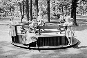 Children riding a Merry-go-round roundabout in Clark Park, D
