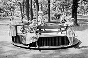 Children riding a Merry-go-round roundabout in Clark Park, D Children riding a Merry-go-round roundabout in Clark Park, D