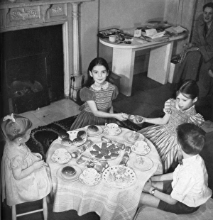 <b class=qtipBold><figcaption>Children's party, 1953</figcaption></b><br>Four children enjoy a charming (if a little sparse) looking Christmas tea party. The girls are wearing smocked party dresses by Lindsay Maid and two of them pull crackers while their companions look on politely. Date: 1953<br><em>© Illustrated London News Ltd/Mary Evans</em> Children's party, 1953