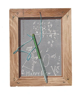 Childs slate with pen and scribbles on a New Year card Childs slate with pen and scribbles on a New Year card