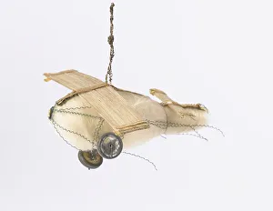 <b class=qtipBold><figcaption>Christmas tree decoration</figcaption></b><br>Small aeroplane ornament with a clear glass body covered in cream fibre secured with wire, metal wheels, and two sets of wings made from plant fibre. Thought to date c.1930-1940 and possibly used as a Christmas decoration. Date: 1930-1940<br><em>© The Geffrye Museum of the Home / Mary Evans Picture Library</em> Christmas tree decoration