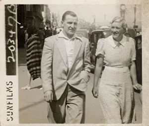 Greenhill Gallery: Couple strolling along the front on holiday in Weymouth