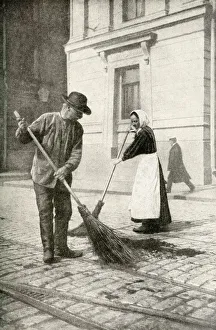 Couple sweeping a street, Helsingfors, Finland Couple sweeping a street, Helsingfors, Finland
