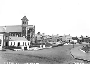 Prints of The Crescent. Portstewart - a view of a road and varied buildings, one of which is a Church. (Location: Northern Ireland; County Londonderry; Portstewart). Date: circa early 1900s Northern Ireland Prints: Early 20th Century Print of Portstewart's The Crescent