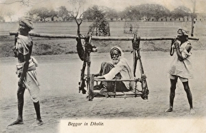 Dhule, India - A beggar is carried in a two-man litter Dhule, India - A beggar is carried in a two-man litter