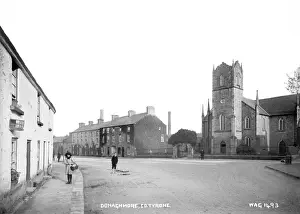 Prints of Donaghmore, Co. Tyrone - a view of the town with people to the left and church to the right. (Location: Northern Ireland: County Tyrone: Donaghmore). Date: circa early 1900s County Tyrone Prints: Early 20th Century Print of Donaghmore, Co. Tyrone