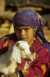 Hurghada Collection: Egypt - a Bedouin girl cuddles a goat; a small