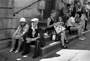 An elderly couple sitting on steps outside Bath Abbey An elderly couple sitting on steps outside Bath Abbey