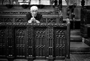 An elderly minister sits to pray in Bath Abbey, England An elderly minister sits to pray in Bath Abbey, England