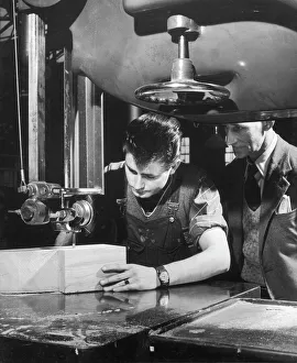 A factory worker cuts a block of wood A factory worker cuts a block of wood
