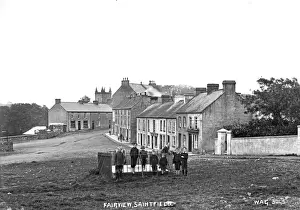 Prints of Fairview, Saintfield - a view of a street by a green with a crowd of children on the grass beside a railing and the buildings behind. (Location: Northern Ireland; County Down; Saintfield) Down Prints: Early 20th Century Print of Saintfield Fairview Street Scene