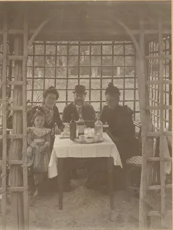 A family, three adults and a little girl, sitting in a rustic A family, three adults and a little girl, sitting in a rustic