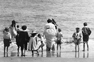 <b class=qtipBold><figcaption>Family at the beach</figcaption></b><br>The Advance, mother and children at the beach walking into the sea, paddling at the seaside on a summer holiday 1902 Date: 1902<br><em>© Mary Evans / National Archives</em> Family at the beach
