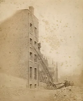 A firefighter in action on a wheeled ladder escape A firefighter in action on a wheeled ladder escape