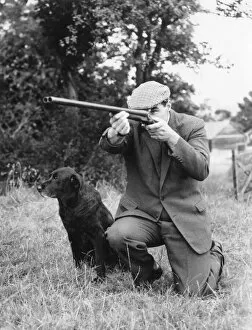Flat Gallery: Gamekeeper taking aim, his dog at his side