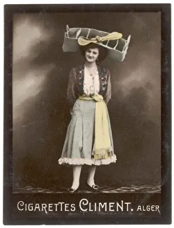 <b class=qtipBold><figcaption>Girl in Aeroplane Hat</figcaption></b><br>A smiling young woman balances on her head a large & unusual aeronautically inspired hat based on a bi-plane. It has an extremely big propellor.<br><em>© Mary Evans Picture Library</em> Girl in Aeroplane Hat