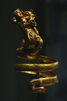 Gold armband with male triton holding a small winged Eros. ( Gold armband with male triton holding a small winged Eros. (