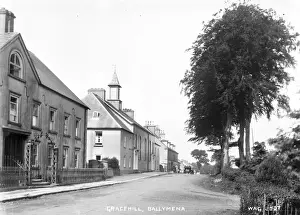 Prints of Gracehill, Ballymena - a street scene of this Moravian settlement with a car in the distance. (Location: Northern Ireland; County Antrim; Gracehill). Date: circa early 1900s Antrim Prints: Early 20th Century Gracehill Street Scene Print