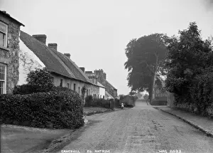 Prints of Gracehill, Co. Antrim - a street scene of this Moravian village, with a motor car and people in the distance. (Location: Northern Ireland; County Antrim; Gracehill). Date: circa early 1900s Antrim Prints: Early 20th-Century Print of Gracehill Village Scene