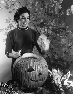 <b class=qtipBold><figcaption>Huge Pumpkin Lantern</figcaption></b><br>A happy housewife cuts the lid into the top of her huge Halloween (or Thanksgiving) pumpkin lantern! Date: 1960s<br><em>© Mary Evans Picture Library</em> Huge Pumpkin Lantern