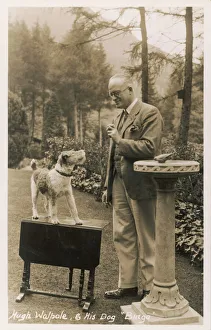 <b class=qtipBold><figcaption>Hugh Walpole/Postcard</figcaption></b><br>SIR HUGH SEYMOUR WALPOLE English novelist with his wire-hired fox terrier Bingo, in the garden of their home at Keswick, Cumbria.<br><em>© Mary Evans Picture Library 2015 - https://copyrighthub.org/s0/hub1/creation/maryevans/MaryEvansPictureID/10142665</em> Hugh Walpole/Postcard