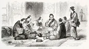 Japanese people sitting on the floor eating their meal using small bowls and chopsticks Japanese people sitting on the floor eating their meal using small bowls and chopsticks