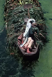 Drifting Gallery: Kashmir, Srinagar. Boatman asleep in shade on back of boat