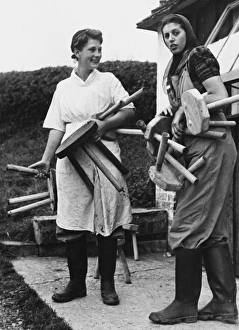 <b class=qtipBold><figcaption>Land Girls WWII</figcaption></b><br>Land Girls, Phyllis Hosford (Assistant in Dolcis shoe shop Oxford Street) and Joan Jacobs (Shop Assistant in Westminster), get ready for milking on a dairy farm with their milking stools during World War II<br><em>© Mary Evans/Robert Hunt Collectio</em> Land Girls WWII