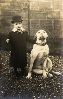 Little boy with large bulldog in a garden, France Little boy with large bulldog in a garden, France