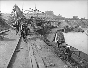 <b class=qtipBold><figcaption>Loading Coal Barges</figcaption></b><br>A pit pony pulling heavy coal trucks along on rails for loading onto barges on a canal in Staffordshire, England.<br><em>© Mary Evans Picture Library</em> Loading Coal Barges