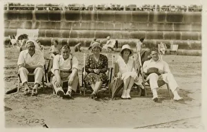 A lovely group photo of five friends (or relatives) sitting on deckchairs on the beach at A lovely group photo of five friends (or relatives) sitting on deckchairs on the beach at