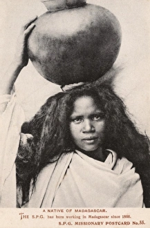 Madagascar - Girl carrying a large round jar Madagascar - Girl carrying a large round jar
