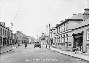Prints of Main Street, Randalstown - a street scene with motor car and people and shops. (Location: Northern Ireland; County Antrim; Randalstown). Date: circa early 1900s Antrim Prints: Early 20th Century Print of Main Street, Randalstown