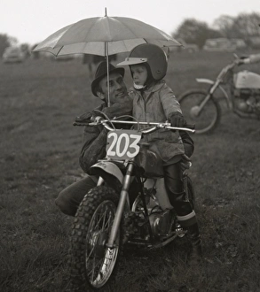Man and boy with junior sized motorcycle Man and boy with junior sized motorcycle
