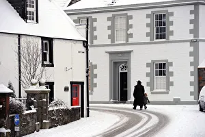 Man in a heavy overcoat walks a small child through the snow Man in a heavy overcoat walks a small child through the snow