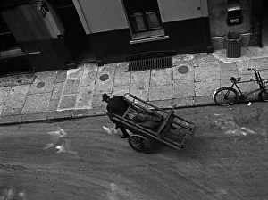 A man pulls a barrow in Marshall Street, London A man pulls a barrow in Marshall Street, London