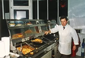 Man serving in fish and chip shop, Cornwall