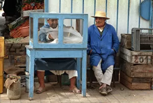 Man sits beside a small food stall in Houmt Souk, Djerba