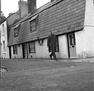 Thumb Gallery: Man walking past Tom Thumb cottages, Eastbourne