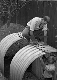 Two men constructing an Anderson shelter