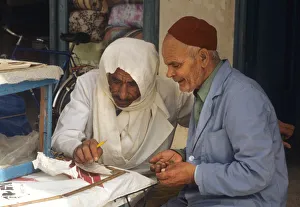 Two men sit beside stall in the market at Houmt Souk, Djerba Two men sit beside stall in the market at Houmt Souk, Djerba