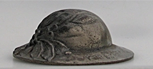 A miniature British Brodie helmet with laurel leaves A miniature British Brodie helmet with laurel leaves