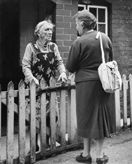 Two neighbours chatting over a fence Two neighbours chatting over a fence