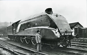Nigel Gresley standing alongside his A4 class steam engine