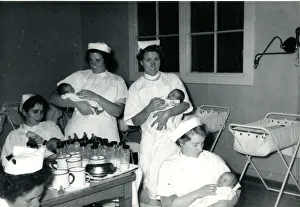 Nurses with babies in hospital nursery Nurses with babies in hospital nursery